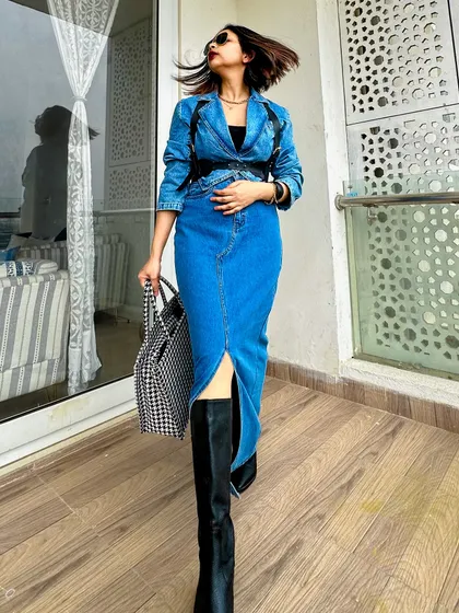 A walking shot, showing the movement of the denim skirt and the confidence this outfit inspires.