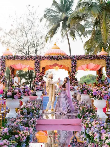 A magnificent mandap on a Goan beach, adorned with a cascade of purple and pink flowers. Mahika and Gautam exchanged vows with the sound of the waves and the rustle of palm trees as their soundtrack.