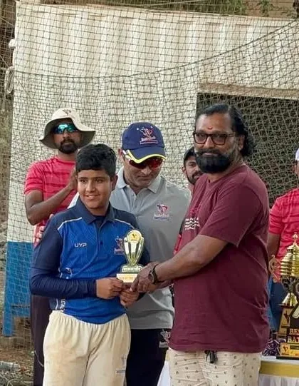 An awards ceremony in progress, with a U-14 player receiving his trophy for an excellent performance.