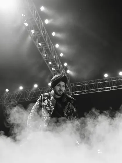 A dramatic, atmospheric shot of Gurdeep Mehndi on stage, enveloped in smoke. We use theatrical effects to create powerful visual moments that make for stunning photographs and lasting memories.