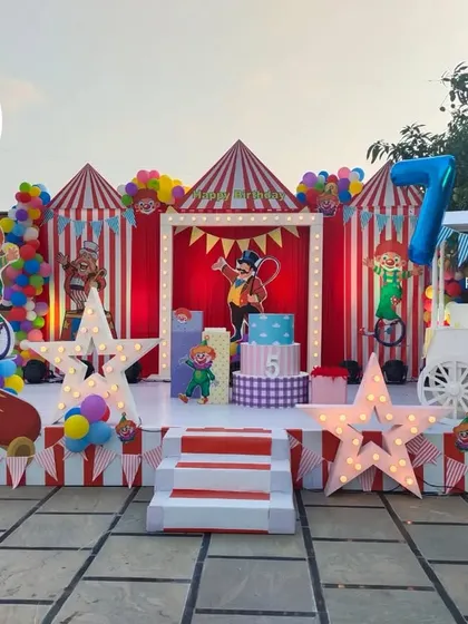 A wide shot of the outdoor carnival setup, showing the scale and detail of the stage, props, and dessert cart.