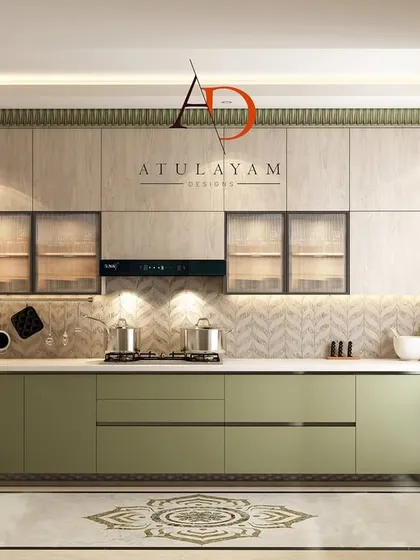 A full view of the U-shaped green and wood kitchen, showcasing the handleless cabinetry, herringbone backsplash, and integrated appliances for a clean, minimalist look.