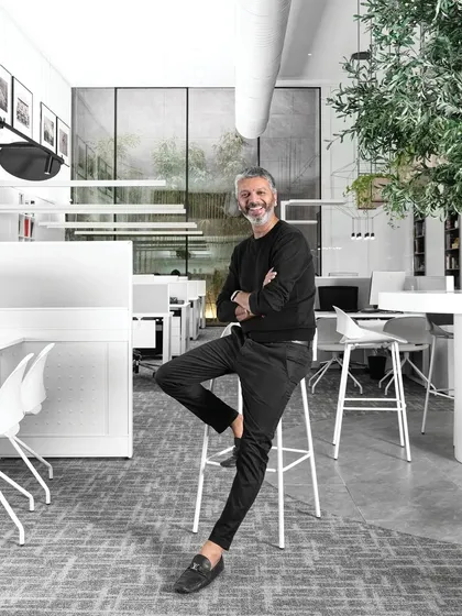 A portrait of me in our studio. The open, minimalist design of our workspace, with its clean lines and integrated greenery, reflects the same principles I apply to my architectural projects.