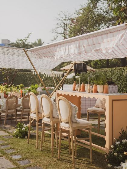 A chic bar setup with high chairs, perfect for guests to grab a drink and enjoy the poolside view.