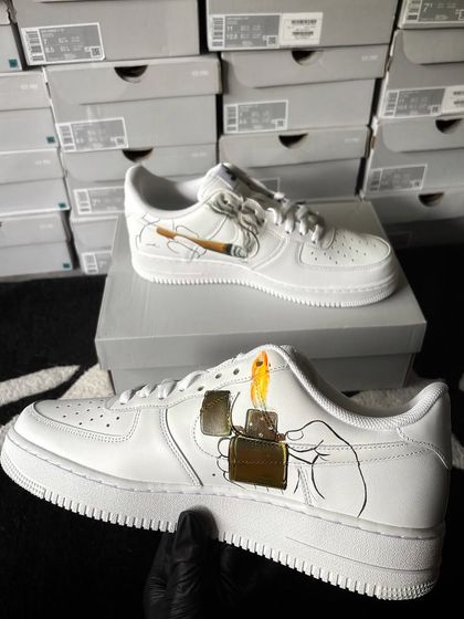 A custom Nike Air Force 1 with a "stoner" theme, featuring a hand lighting a joint.