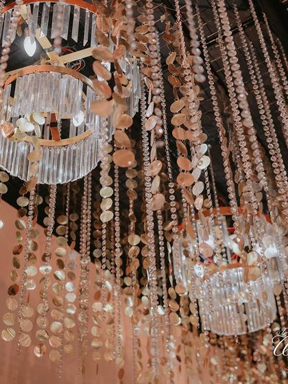 A close-up of the ceiling decor, featuring shimmering shell curtains and modern chandeliers. This kind of detailed layering adds texture and luxury to the event space.