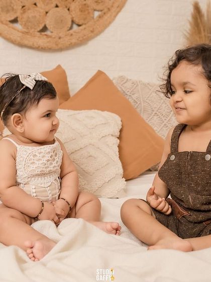 Double the trouble, twice the fun! Two little ones sharing a moment in our studio.