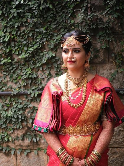 A full view of Chinmayi's stunning bridal attire, showing how the makeup, hair, and saree come together. The puffed sleeves and temple jewellery belt complete this iconic look.