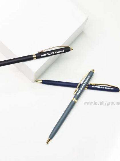 We produce high-quality custom pens perfect for corporate gifting. This image shows a set of elegant metal pens with gold accents, branded for Aurolab Essence.