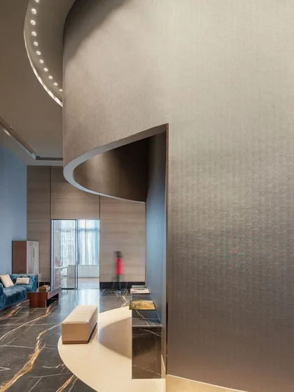 The curved walls in the Godrej South Estate Experience Centre guide visitors naturally through the space. The textured wallpaper and dramatic lighting create a sense of movement and discovery, making the journey between zones as important as the destinations themselves.