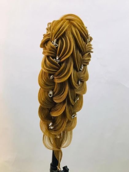 An intricate, cascading braid adorned with crystals. This style is perfect for brides who want a statement look for their special day.