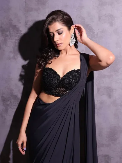 A close-up of the soft curls and side part. This hairstyle is all about understated glamour, letting her natural beauty and the intricate blouse shine.