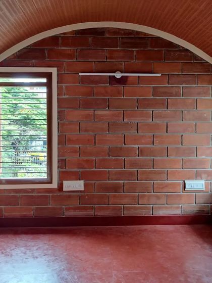 The simple, timeless form of a brick arch gives this room a sense of grace and stability. Paired with a red oxide floor and a vaulted ceiling of exposed brick, the space feels both ancient and modern.