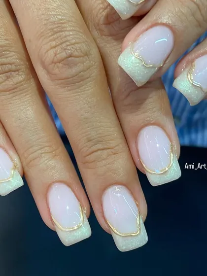 Pearl threads with chrome art. This is a sophisticated French manicure with a shimmery pearl base and a delicate gold chrome line accentuating the tip.