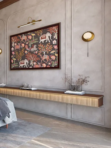 Opposite the bed, a floating console is mounted on a wall with classical molding and a beautiful piece of traditional Indian art, blending old-world charm with modern functionality.
