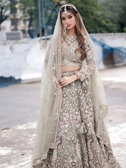 For the modern bride, this pastel green lehenga with detailed threadwork and a matching sheer dupatta is a dream come true. It's perfect for an engagement or a day wedding, complete with a full rental jewellery set.