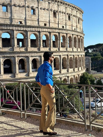 A view from the back, highlighting the shirt's clean lines and how it complements the beige bell-bottom trousers.
