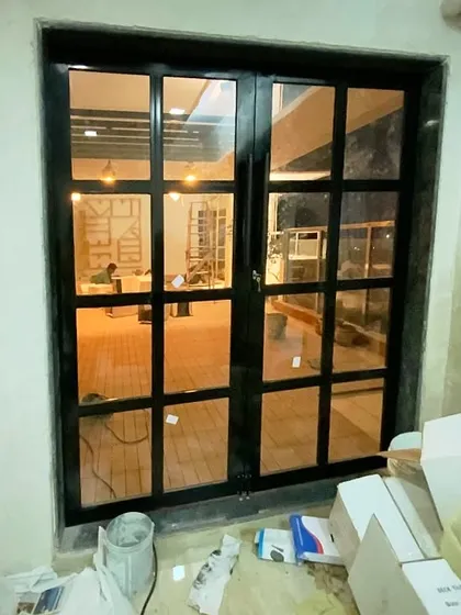 The entrance to your personal paradise. This custom-designed French door now leads to the revamped terrace in Belapur, creating a beautiful transition from the indoor living area to the outdoor lounge.