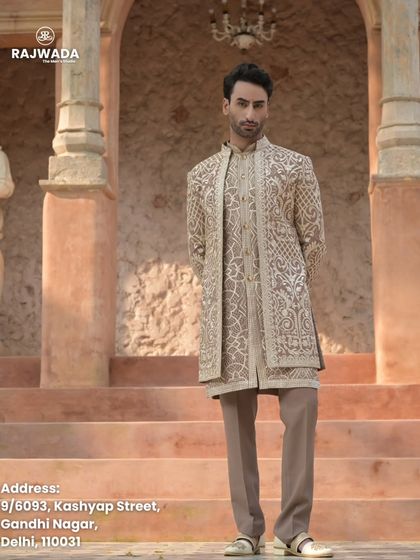 This image captures the grandeur of the beige Indo-Western outfit against a heritage backdrop. It's an outfit designed for a man who appreciates timeless elegance.