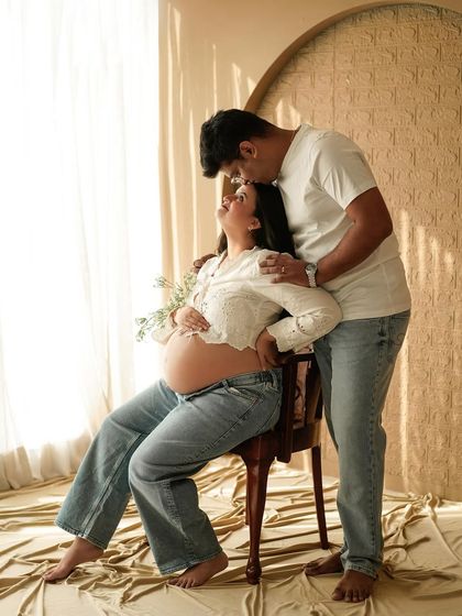 A tender moment between the couple, both dressed in casual white and denim, in our sunlit studio.