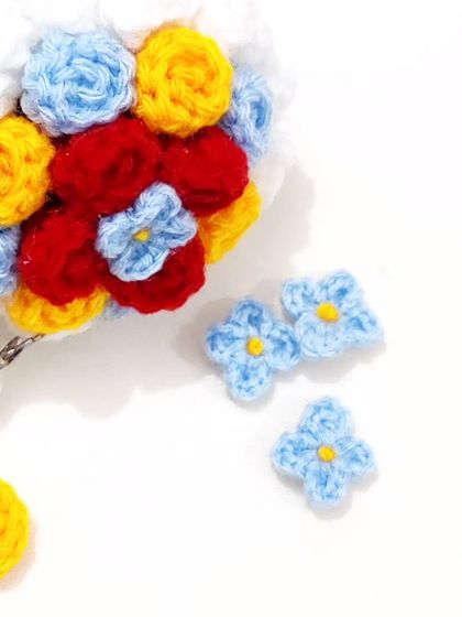 A special Snow White themed mini bouquet keychain, using her signature colors of red, yellow, and blue.