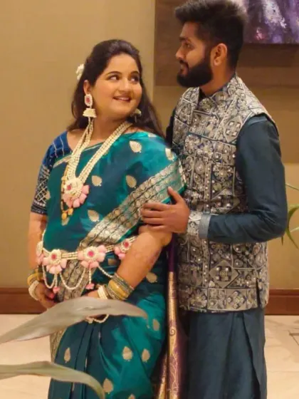 A beautiful couple moment from a baby shower. She is wearing our custom pink and white floral set, including a delicate kamarband.