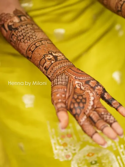 A close-up shot of a bridal arm, showing the intricate bands of elephants and peacocks.