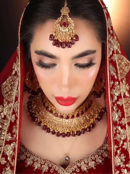A detailed close-up of my international bride's makeup. The focus was on flawless skin, sharp winged eyeliner, and a classic red lip to create an authentic Indian bridal look.