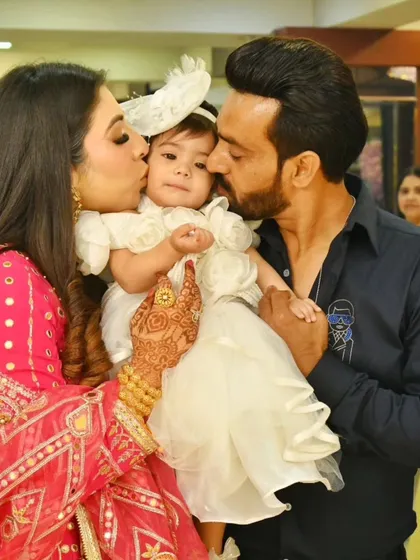 Capturing the love during a big celebration is just as important as the posed shots. This candid moment of parents kissing their daughter on her first birthday shows the warmth and happiness of the day, surrounded by our butterfly-themed decor.