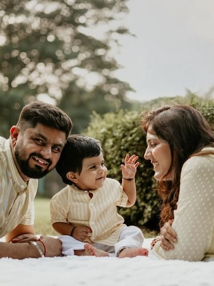 A little wave from a happy baby. Seated on a blanket in the park, this family shares a moment of sweet interaction. My goal is to create a relaxed space where these unscripted connections can happen.