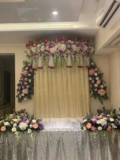 A beautiful floral backdrop with a mix of pastel-colored flowers. The lace-covered base adds a touch of vintage charm to this elegant setup.