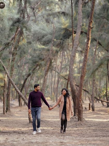 A candid walking shot of a couple holding hands in a beautiful, dense forest. My focus is on capturing your natural interactions in these serene settings.