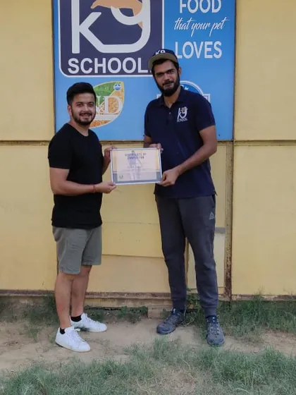 Receiving a certificate from my mentor at K9 School. Continuous learning is a core part of my professional life, as it allows me to bring the most effective and humane training methods to my clients.