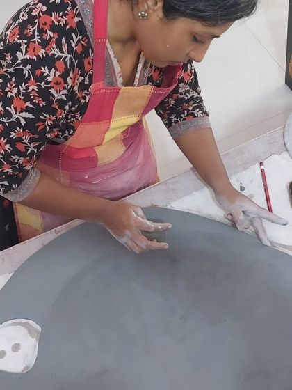 The process of creating a large mural begins with a simple slab of clay. My student is carefully shaping the clay, getting it ready for the intricate fish design she planned. It's a testament to her dedication and willingness to take on a challenge.
