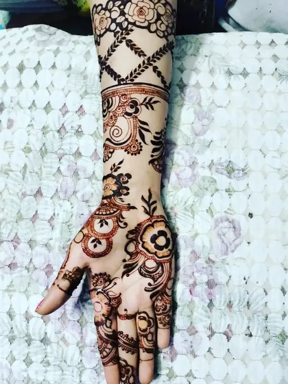 An Indo-Arabic floral design on a single arm. The pattern starts with a floral grid on the wrist and flows down into a beautiful vine on the hand.