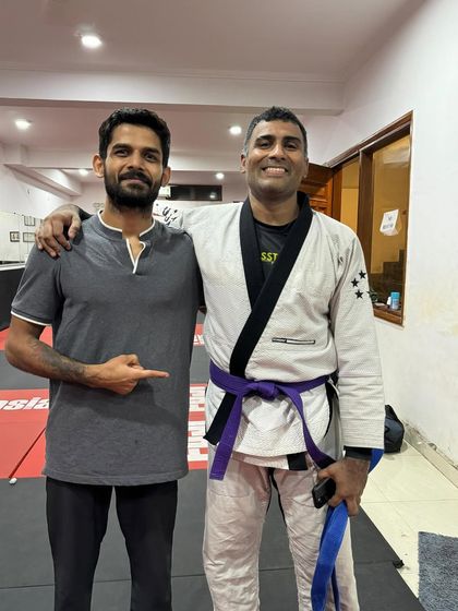 Another member of the coaching staff celebrating with our newly promoted purple belt. It takes a village to build a fighter.