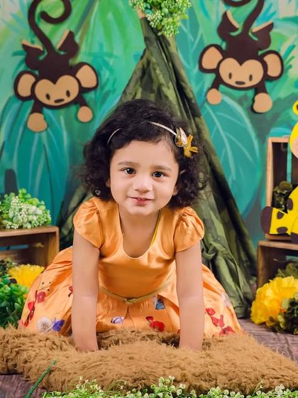 A beautiful portrait of a toddler girl posing in her jungle-themed photoshoot, ready for her next adventure.