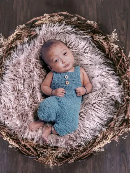 A simple and rustic newborn photo with the baby nestled in a twig basket on a wooden floor. This highlights the natural beauty of your baby.
