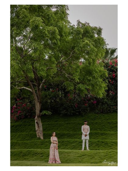Another perspective of the couple on the green hills, emphasizing the scale of the landscape.