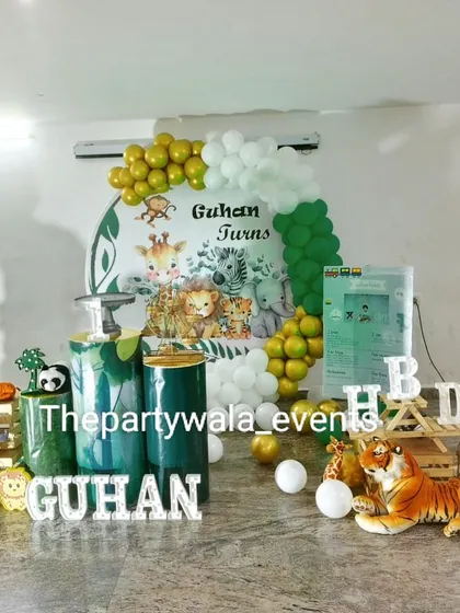 A "Wild and Classy" jungle theme with green and white pedestals. The setup includes a variety of animal cutouts and a beautiful balloon arch.