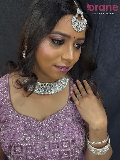 A modern reception or sangeet look featuring a lavender lehenga with silver jewelry. We teach our students to create looks for all wedding functions.