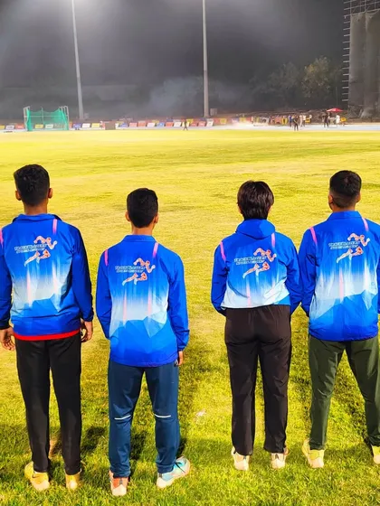 Team Trackblazers, united and proud, looking out over the field at the Khelo India Youth Games. We are a team, on and off the track.