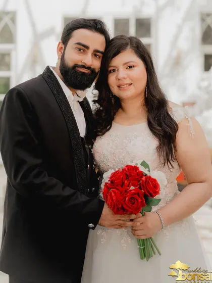 A classic and happy portrait of the couple. The bride holds a bouquet of red roses, symbolizing their love.