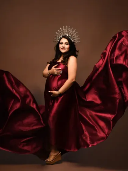 A regal and powerful maternity portrait. The combination of a flowing red gown and a delicate crown creates a truly majestic look, celebrating the queen that every mother-to-be is.