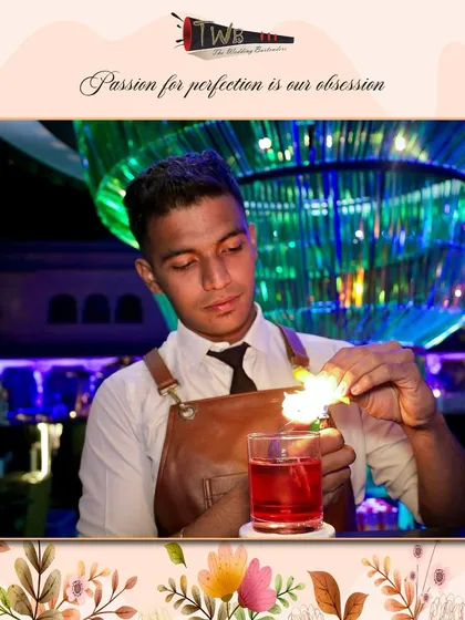A bartender carefully flames an orange peel over a Negroni. This classic technique releases citrus oils that add a bright, aromatic complexity to the cocktail.