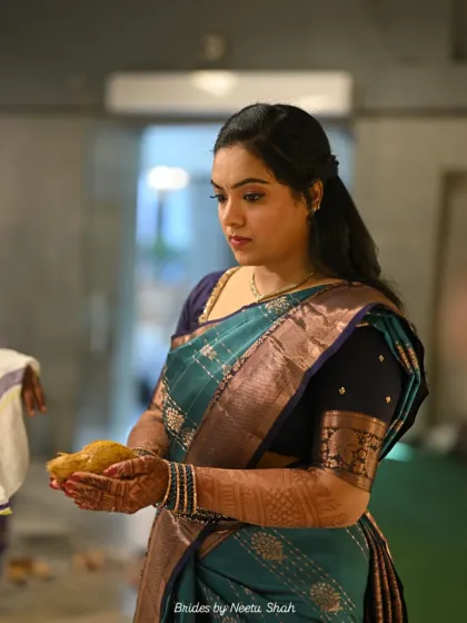 A candid moment during a South Indian engagement ceremony. The bride's poised and graceful demeanor is complemented by her traditional attire and subtle, elegant makeup.