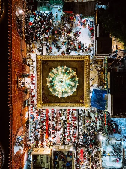 A closer top-down view of the central shrine at Nizamuddin, its dome glowing like a jewel amidst the surrounding crowd.