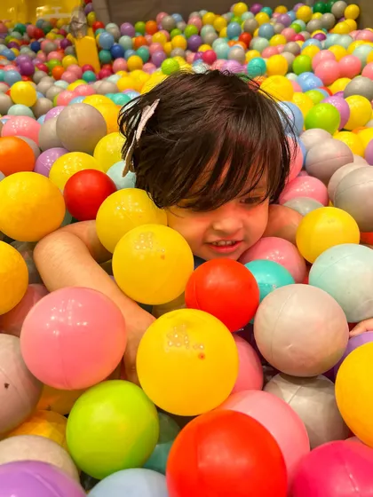 A happy smile from within the ball pit. It's a simple pleasure that brings so much happiness.