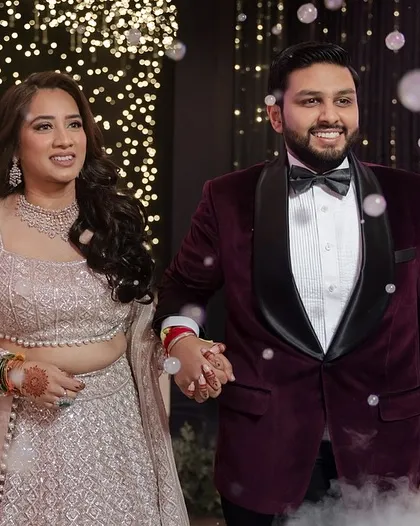 The couple's grand entrance to their Sangeet, surrounded by bubbles and a backdrop of twinkling lights.