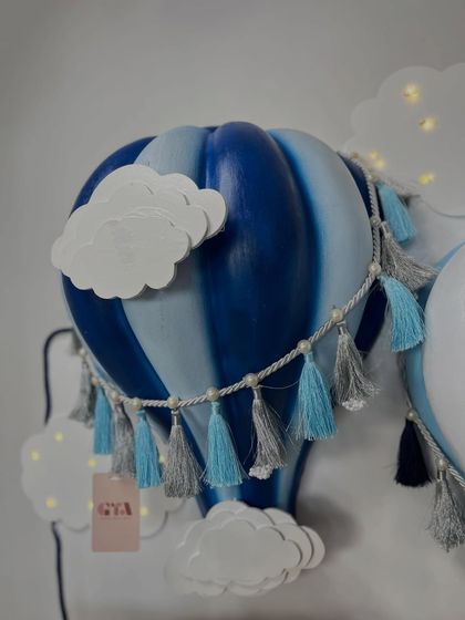 A detailed shot of the handcrafted blue hot air balloon lamp with tassel accents.